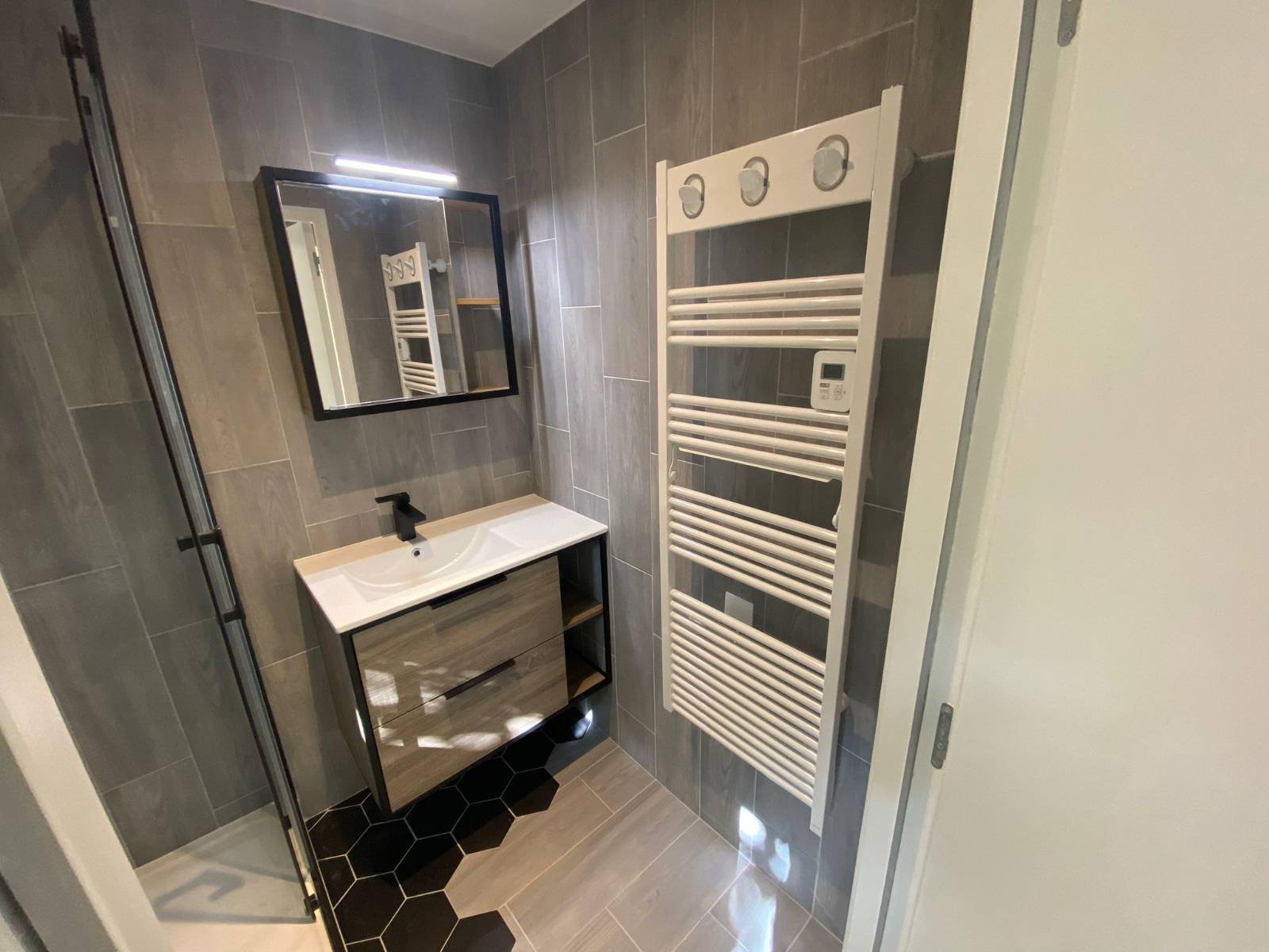 Rénovation complète d’un T2 à Poitiers : cuisine noire, sols métissés & sdb graphique